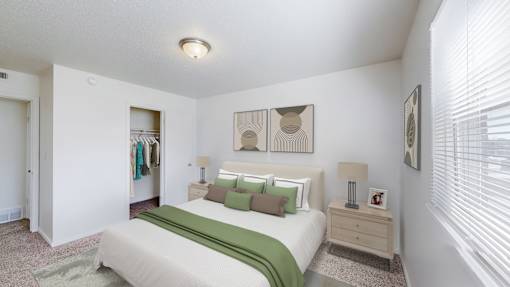 A bedroom with a bed, nightstand, and two lamps.