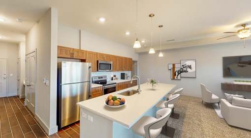 A modern kitchen with a refrigerator, sink, and a counter with chairs.