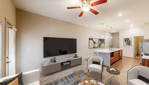 A living room with a television, couch, and chairs.