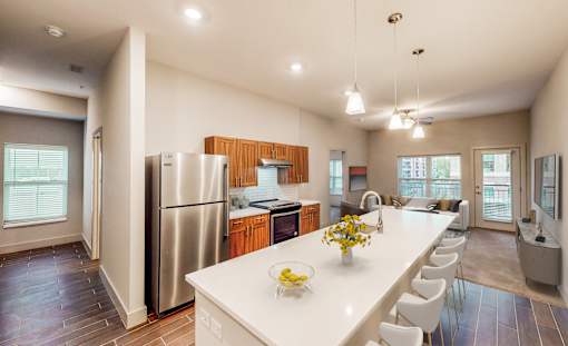 A kitchen with a white counter top and stainless steel appliances.