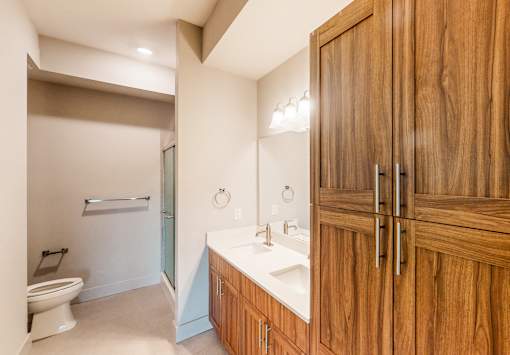 A bathroom with wooden cabinets and a white sink.
