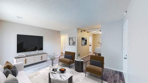 a living room with a couch and chairs and a tv