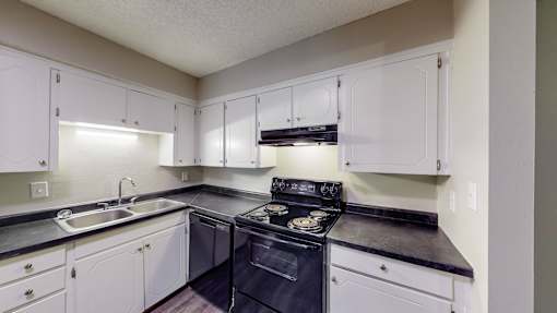 a kitchen with black appliances and white cabinets