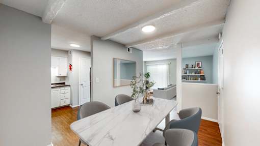 a dining room and kitchen with a marble table and chairs