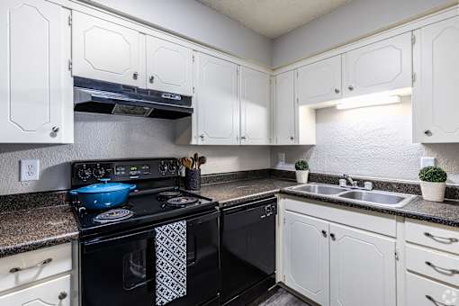 a kitchen with black appliances and white cabinets