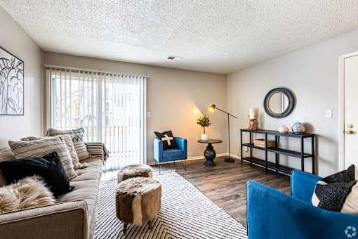 a living room with a couch and chairs and a sliding glass door