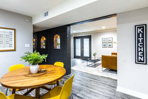 a dining room with a wooden table and yellow chairs