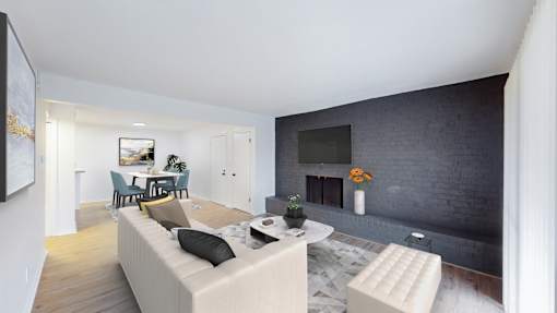 A living room with a couch, a coffee table, and a fireplace.