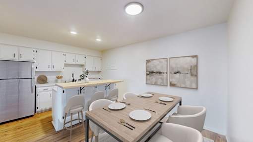 A modern kitchen with a dining table set for two.