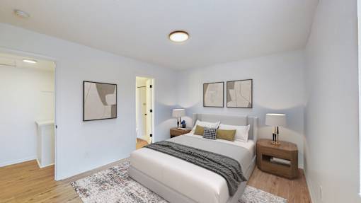A bedroom with a bed, nightstands, and pictures on the wall.