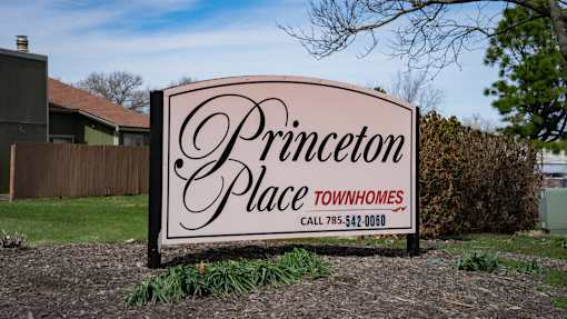 A sign for Princeton Place Townhomes with a phone number on it.