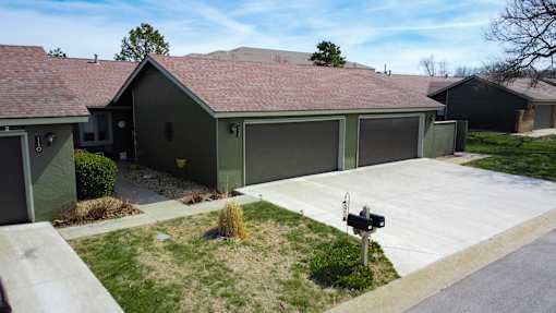 A house with a brown roof and a grey garage door.
