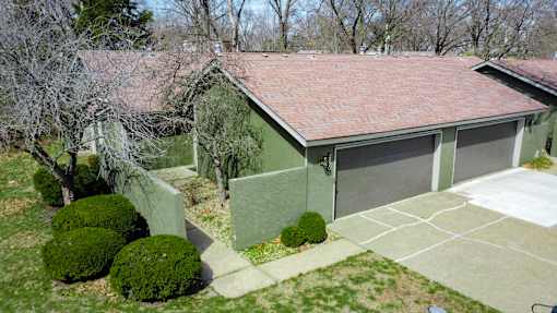 A house with a red roof and a green garage door.