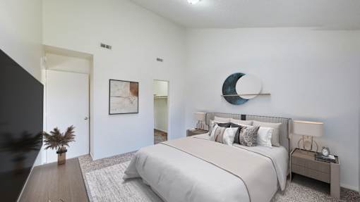 A bedroom with a large bed and a nightstand with a lamp.
