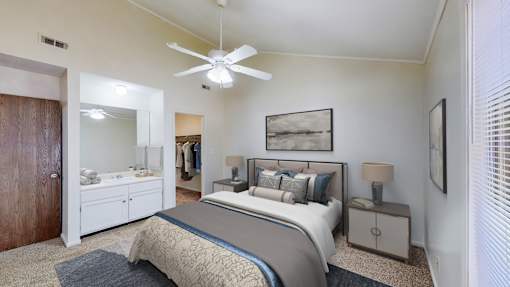 A bedroom with a bed, nightstand, and a ceiling fan.