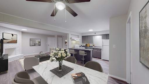 A modern dining room with a marble table and a ceiling fan.