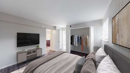 A bedroom with a large bed and a television on the wall.