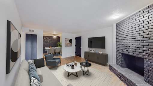 A living room with a grey couch, a coffee table, and a fireplace.