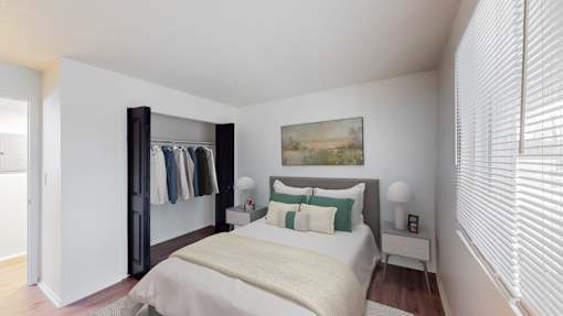 A bedroom with a bed, a wardrobe, and a painting on the wall.