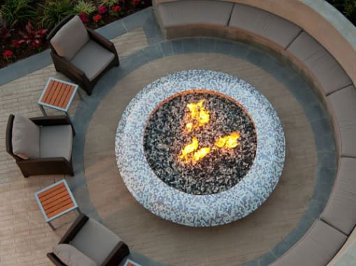 A fire pit in the middle of a patio surrounded by chairs at Circa 37 Apartments, San Diego, CA, 92108
