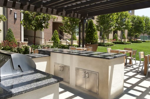 A patio with a barbecue grill and seating area at Circa 37 Apartments, California