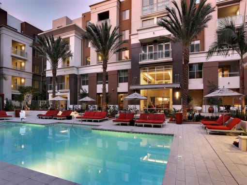 A large swimming pool in front of a building with palm trees at West Park Apartments, California