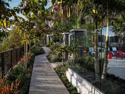 A walkway with a metal fence on the left and a white wall on the right at West Park Apartments, San Diego, 92108