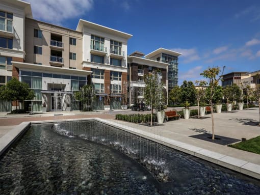 A modern building with a water feature in front at West Park Apartments, California