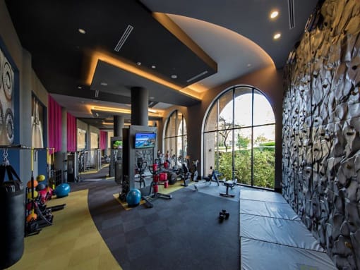 A gym with a variety of equipment including a treadmill, weights, and a punching bag at West Park Apartments, California, 92108