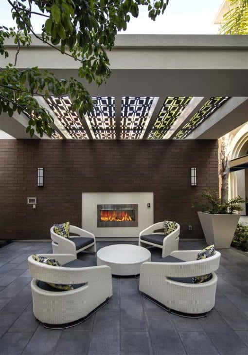 A patio with a fireplace and chairs. at West Park Apartments, San Diego, 92108