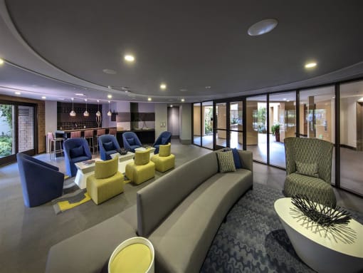 A modern living room with a curved sofa and a coffee table at West Park Apartments, San Diego, California