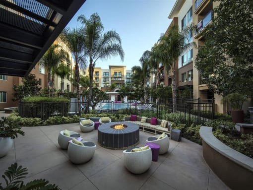 A patio with a fire pit and seating area at West Park Apartments, San Diego
