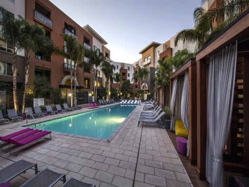 A long rectangular pool with lounge chairs on the side at West Park Apartments, California
