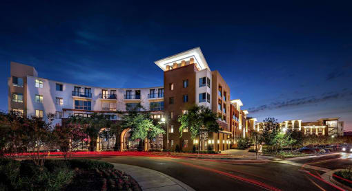 A modern building with a lit up walkway in front at West Park Apartments, San Diego, CA, 92108