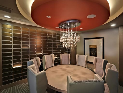 A modern dining room with a round table and grey chairs at West Park Apartments, San Diego, California