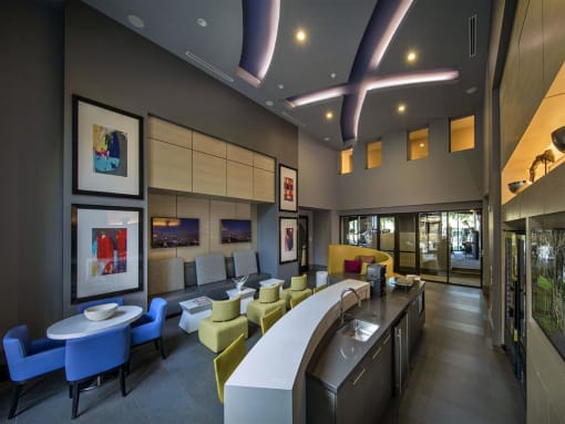 A modern cafe with blue and yellow chairs and a counter at West Park Apartments, San Diego, CA