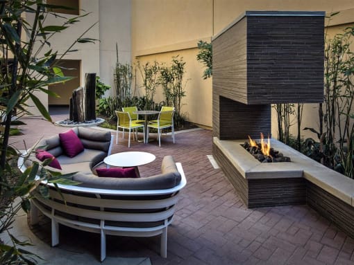A modern outdoor seating area with a fireplace at West Park Apartments, San Diego, 92108