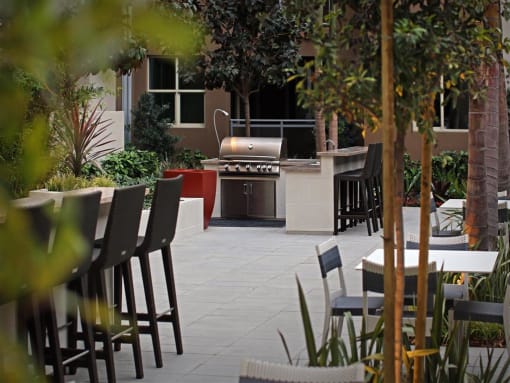 A patio with chairs and a grill at West Park Apartments, San Diego, CA, 92108