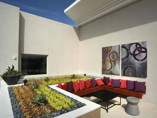A modern patio with a bench, table, and potted plants at West Park Apartments, San Diego, CA