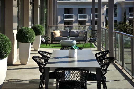 A table with chairs and a potted plant on a balcony at Circa 37 Apartments, California
