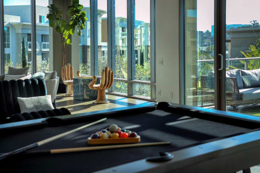 A pool table with a cue and balls on it at Circa 37 Apartments, San Diego