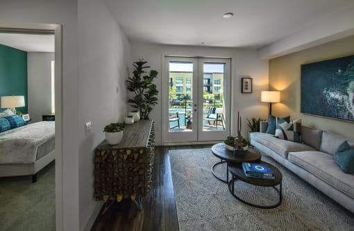A living room with a couch, coffee table, and a painting on the wall at Purl Apartments, San Diego
