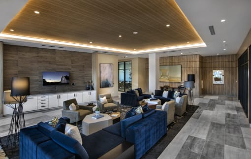 A modern living room with a dark blue sofa and a wooden ceiling at Purl Apartments, San Diego, California