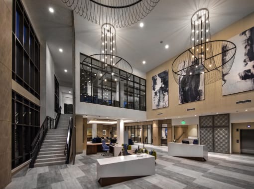 A modern office lobby with a staircase and a reception desk at Purl Apartments, San Diego, 92108