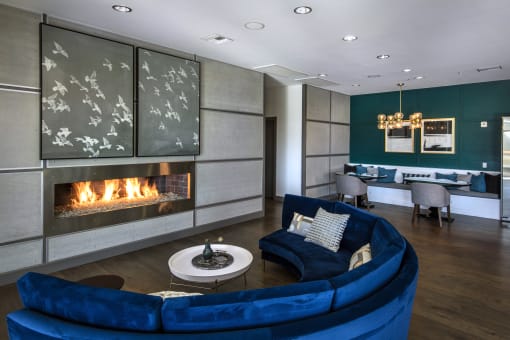 A blue couch is in front of a fireplace in a modern living room at Circa 37 Apartments, San Diego, 92108
