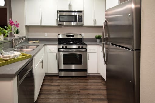A modern kitchen with a stainless steel refrigerator, oven, and microwave. at Circa 37 Apartments, San Diego, California