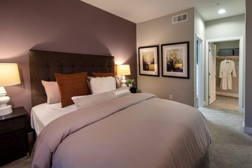 A bedroom with a large bed and a white robe hanging on the door at Circa 37 Apartments, California