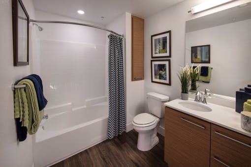 A bathroom with a toilet, sink, and shower at West Park Apartments, San Diego, 92108