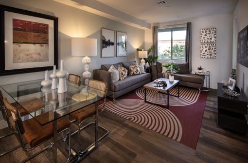 A living room with a glass table and brown chairs at West Park Apartments, San Diego, 92108