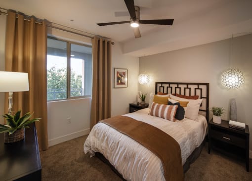 A bedroom with a large bed and a ceiling fan at West Park Apartments, California